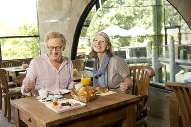 Lächelndes älteres Paar beim Frühstück in einem Cafe - TOYF001260