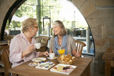 Lächelndes älteres Paar beim Frühstück in einem Cafe - TOYF001261