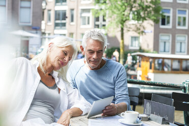 Niederlande, Amsterdam, älteres Paar mit digitalem Tablet in einem Straßencafé - FMKF002060