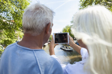 Niederlande, Amsterdam, älteres Paar beim Fotografieren am Stadtkanal - FMKF002036