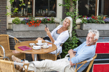 Niederlande, Amsterdam, entspanntes älteres Paar in einem Straßencafé - FMKF002033