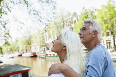 Netherlands, Amsterdam, senior couple at town canal looking up - FMKF002023