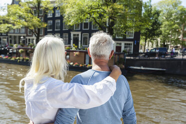 Niederlande, Amsterdam, älteres Paar umarmt sich am Stadtkanal - FMKF002005