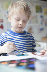 Porträt eines blonden kleinen Jungen, der mit Aquarellfarben malt - RBF002999
