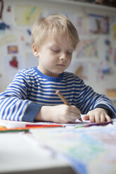 Portrait of blond little boy painting with crayon - RBF002997