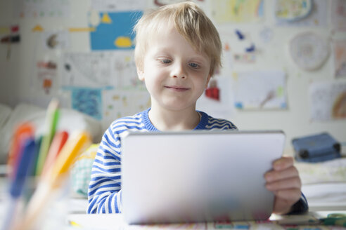 Porträt eines lächelnden kleinen Jungen mit digitalem Tablet - RBF002994