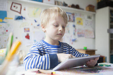 Porträt eines blonden kleinen Jungen mit digitalem Tablet - RBF002993