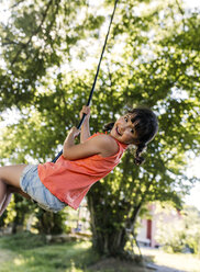 Portrait of little girl swinging in the garden - MGOF000581