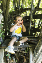 Portrait of screaming little girl sitting in the garden - MGOF000582