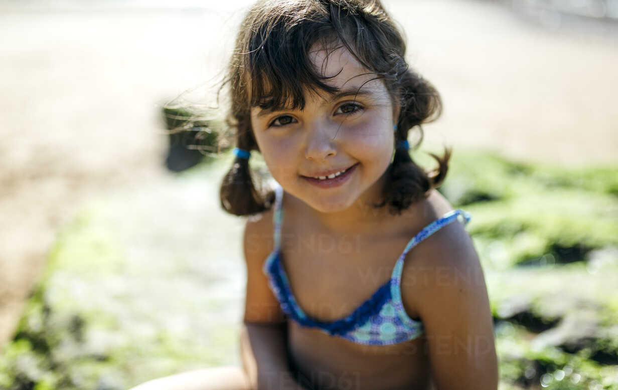 Portrait of a smiling little girl on the beach stock photo - OFFSET