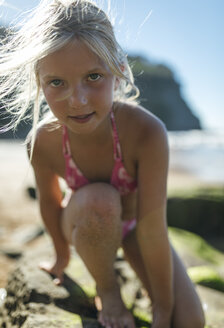 Portrait of little girl climbing on a rock at the beach - MGOF000595