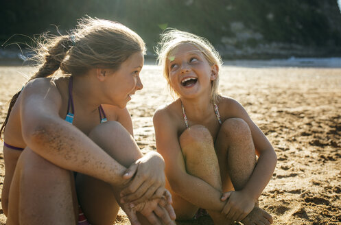 Zwei Schwestern, die zusammen am Strand Spaß haben - MGOF000603