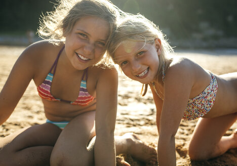 Portrait of two sisters head to head on the beach - MGOF000606