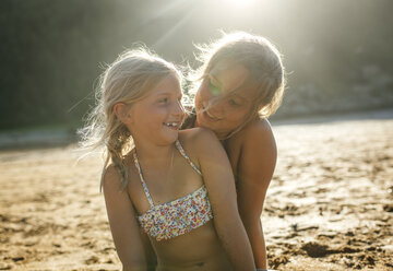 Zwei Schwestern, die zusammen am Strand Spaß haben - MGOF000607