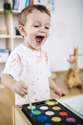 Porträt eines lachenden kleinen Jungen, der mit Aquarellfarben malt - JRFF000025