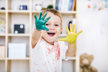 Porträt eines lächelnden kleinen Jungen, der seine bemalten Hände zeigt - JRFF000023