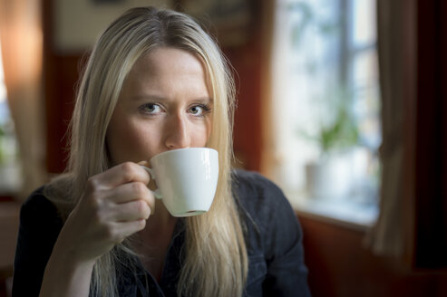Portrait of blond woman drinking cup of coffee - FRF000317