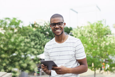 Junge afroamerikanische Studentin mit digitalem Tablet und Kopfhörern - EBSF000877