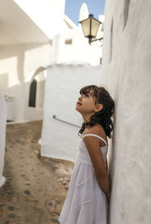 Spain, Balearic Islands, Menorca, Binibeca, little girl leaning against facade looking up - MGOF000647