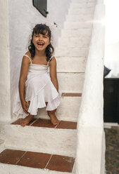 Spain, Balearic Islands, Menorca, Binibeca, portrait of laughing little girl sitting on a step - MGOF000649