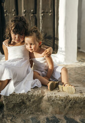 Spanien, Balearen, Menorca, Binibeca, Porträt von zwei kleinen Schwestern, die nebeneinander auf einer Treppe sitzen - MGOF000650