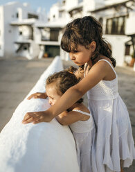 Spain, Balearic Islands, Menorca, Binibeca, two little sisters wearing white summer dresses - MGOF000655