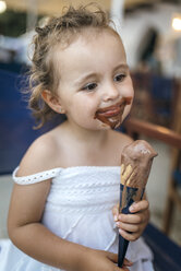 Porträt eines lächelnden kleinen Mädchens mit Schokoladeneis um den Mund - MGOF000657