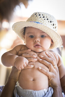 Portrait of baby boy with straw hat being held - ABAF001912