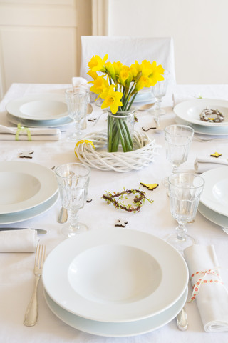 Gedeckter Tisch mit Narzissen zur Frühlingszeit, lizenzfreies Stockfoto