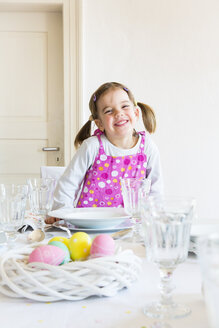 Porträt eines lächelnden kleinen Mädchens, das am gedeckten Tisch sitzt - LVF003778