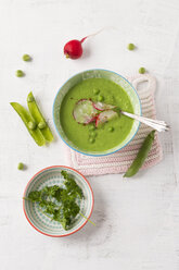 Fresh pea soup with red radishes in bowl - MYF001144