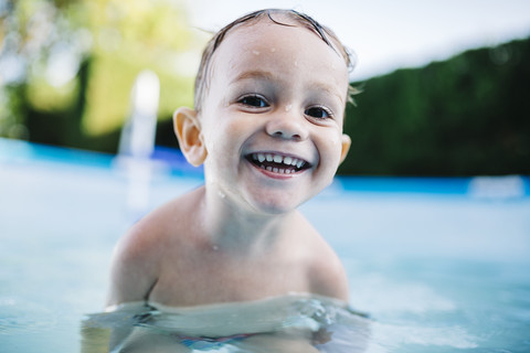 Porträt eines glücklichen kleinen Jungen in einem Planschbecken, lizenzfreies Stockfoto