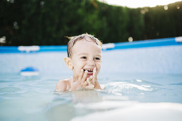 Portrait of happy little boy in a paddling pool - JRFF000053