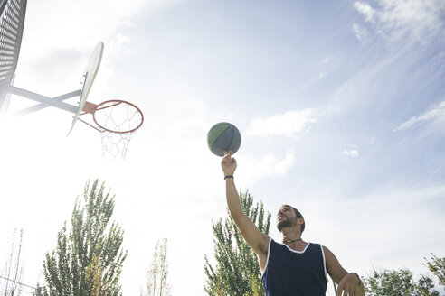 Mann, der einen Basketball auf seinem Finger dreht - ABZF000108