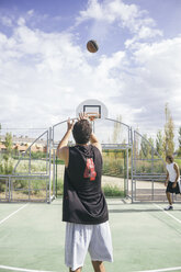 Young man throwing basketball - ABZF000111