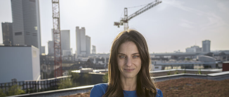 Deutschland, Frankfurt, Porträt einer jungen Frau auf einer Dachterrasse - RIBF000262
