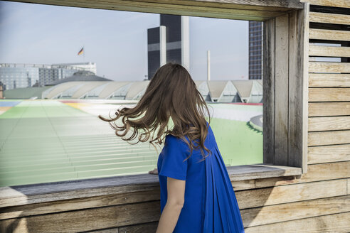 Deutschland, Frankfurt, Geschäftsfrau in blauem Kleid mit Blick auf die Landschaft - RIBF000293