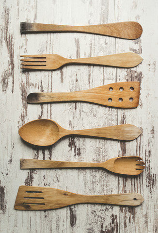Reihe von sechs verschiedenen hölzernen Küchenutensilien auf hölzernem Hintergrund, lizenzfreies Stockfoto