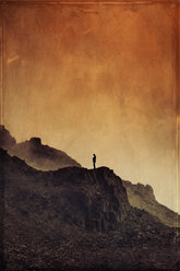 Italy, Lombardy, Alps, Man on rock spur, red sky, textured effect - DWIF000599