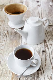Tasse mit schwarzem Filterkaffee und Kaffeekanne auf Holz - EVGF002168