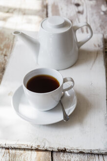 Tasse mit schwarzem Kaffee und Kaffeekanne auf Holz - EVGF002167