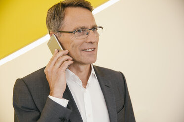 Porträt eines reifen Mannes mit Brille, der mit einem Smartphone telefoniert - MFF002132