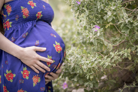 Schwangere Frau hält ihren Bauch, lizenzfreies Stockfoto