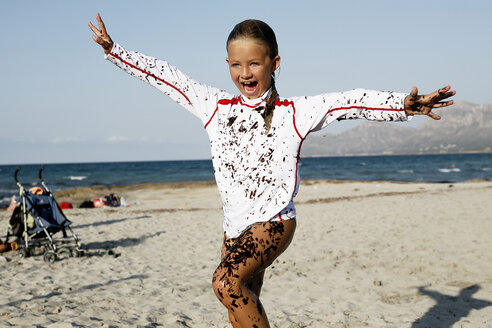 Spanien, Mallorca, lachendes kleines Mädchen, bedeckt mit Seetang am Strand - TMF000035