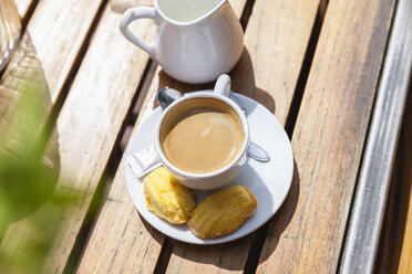 Tasse Kaffee mit Keksen auf dem Tisch im Freien - FMKF002117