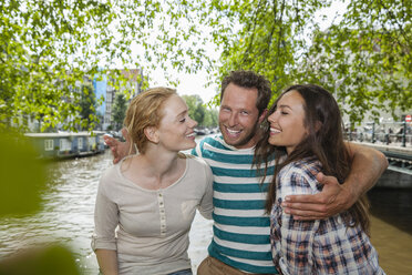 Niederlande, Amsterdam, glückliche Freunde am Stadtkanal - FMKF002134