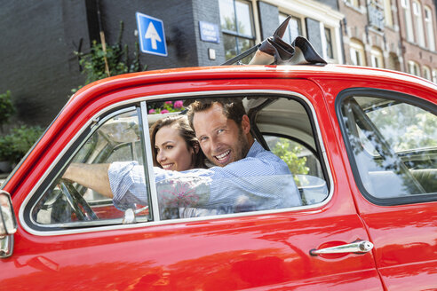 Niederlande, Amsterdam, glückliches Paar mit Kleinwagen in der Stadt - FMKF002159