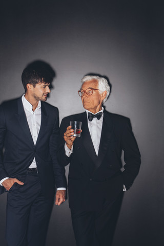 Junger Mann und eleganter älterer Mann mit Getränk, lizenzfreies Stockfoto