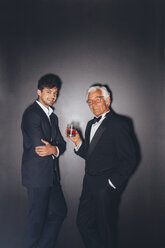Smiling young man and elegant senior man holding drink - CHAF001454