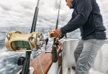 Spain, Asturias, Fisherman on fishing boat on Cantabrian Sea - MGOF000703